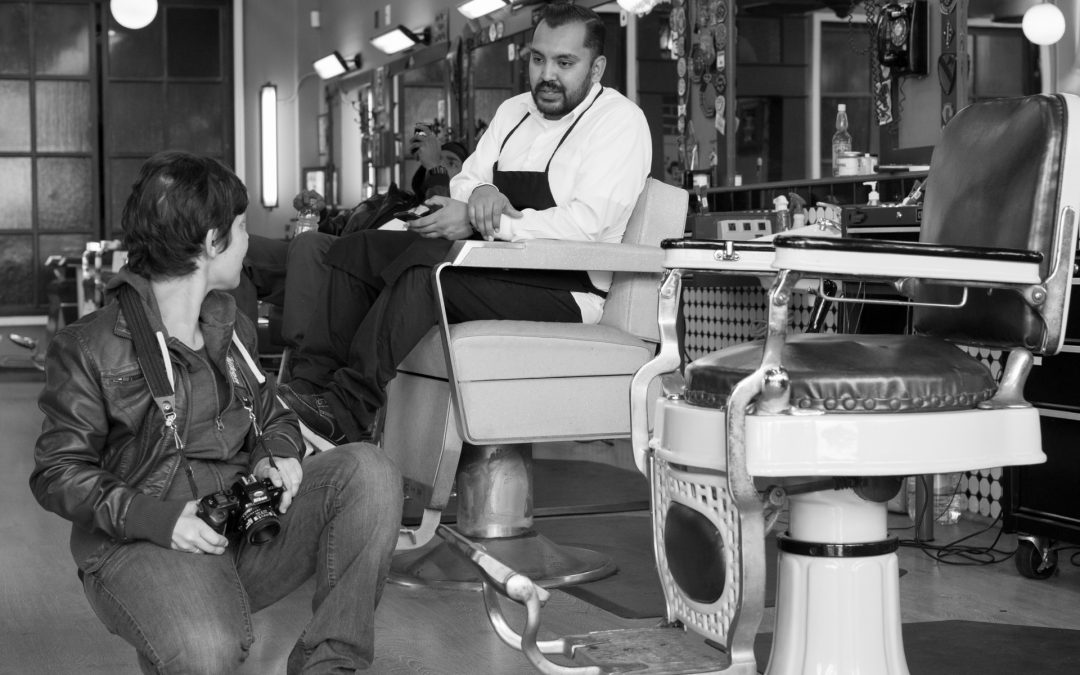 My friend at the barbershop next to a barber, with the old time chairs