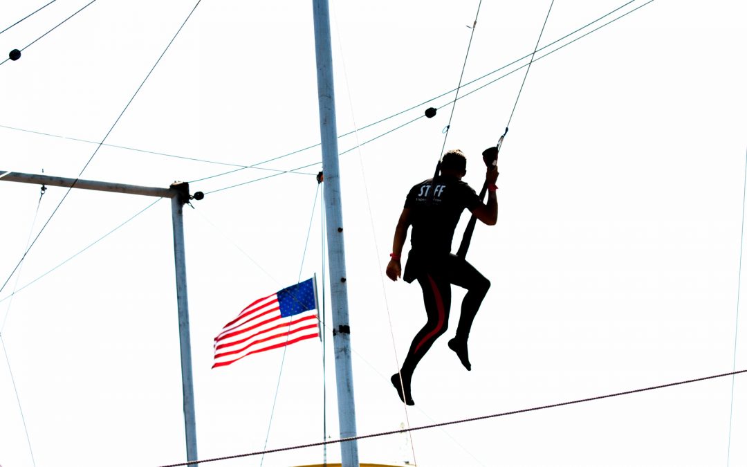 Man on trapeze with American flag